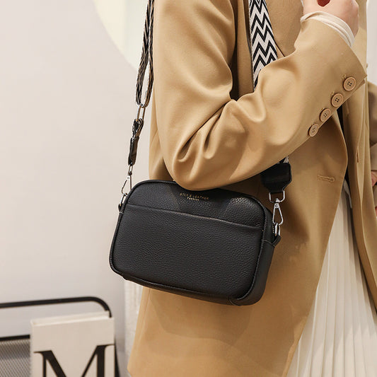 Women's genuine leather small square crossbody bag with rhombus embroidered design and wide shoulder strap in black.