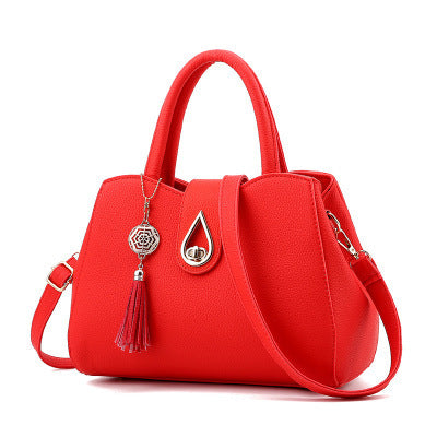 Stylish red women's top-handle handbag featuring embossed PU leather, tassel decoration, lock closure, and spacious interior.
