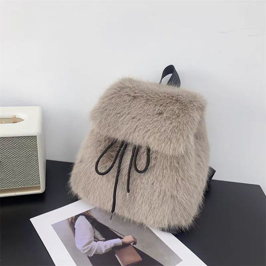 Lightweight plush drawstring flap backpack for women with soft fabric, flap closure, and streetwear design in pink.
