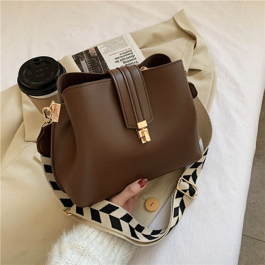 Women's PU leather bucket bag available in black, brown, and dark brown with an urban retro style and crossbody shoulder strap.