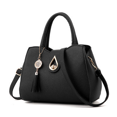 Elegant black women's luxury tassel top-handle handbag made from premium embossed PU leather with secure lock closure and shoulder strap.