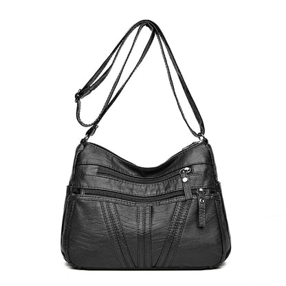 Close-up of hardware and closure detail on soft washed-leather crossbody bag